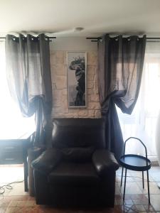 uma sala de estar com uma cadeira de couro e uma mesa em Vieille Ville 1 - Luca's Apartment, 1 bedroom, max 2 adults and 2 kids em Antibes