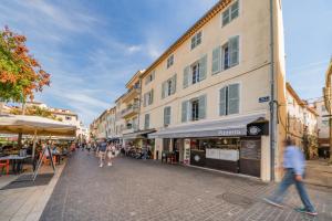 a group of people walking down a street with buildings at Joli 2 pièces - Coeur de Ville - AW in Antibes
