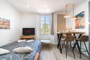 a bedroom with a bed and a table and a dining room at Joli 2 pièces - Coeur de Ville - AW in Antibes