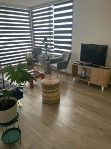 een woonkamer met stoelen en een flatscreen-tv bij Hermoso departamento in Iquique