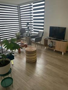 a living room with chairs and a flat screen tv at Hermoso departamento in Iquique