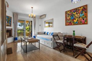 ein Wohnzimmer mit einem Sofa und einem Tisch in der Unterkunft Seaview with private garden 5 minutes walk to the beach and amenities in Sitio de Calahonda