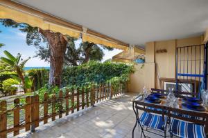 eine Terrasse mit einem Tisch, Stühlen und einem Baum in der Unterkunft Seaview with private garden 5 minutes walk to the beach and amenities in Sitio de Calahonda