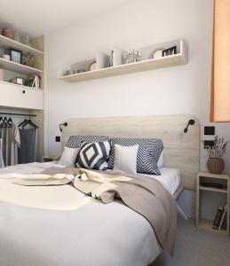 1 dormitorio con 1 cama blanca grande con almohadas en Camping Lido Verbano, en Castelletto sopra Ticino