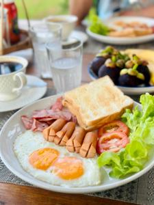 un plato de desayuno con huevos tocino y tostadas en Ideal View Villa lanna en Ban Pa Lan