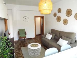 H&H Suite Plaza de Toros في غرناطة: غرفة معيشة مع أريكة وطاولة