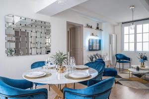 圖爾的住宿－Le Saint-Martin - PrestiPlace Tours，一间配备有白色桌子和蓝色椅子的用餐室