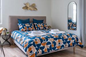 1 dormitorio con 1 cama con edredón azul y naranja en Le Saint-Martin - PrestiPlace Tours en Tours