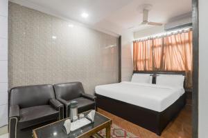 a small bedroom with a bed and a chair at OYO The Casa Picolla in Bankipur