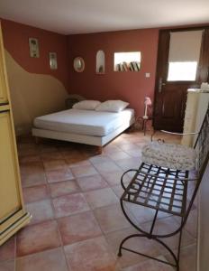 ein Schlafzimmer mit einem Bett und Fliesenboden in der Unterkunft Le gîte d'Anthénéa in Saint-Christol-lès-Alès