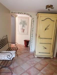 Habitación con armario amarillo y suelo de baldosa. en Le gîte d'Anthénéa en Saint-Christol-lès-Alès