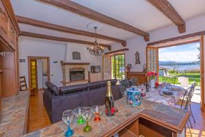 ein Wohnzimmer mit einem Sofa und einem Tisch mit Weingläsern in der Unterkunft Villa Martine Au Bord Du Lac - Happy Rentals in Cadrezzate