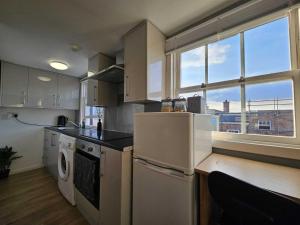 a kitchen with white appliances and a large window at Bee Accommodations - Studio in Leicester