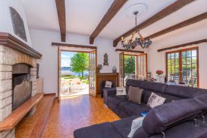 ein Wohnzimmer mit einem Sofa und einem Kamin in der Unterkunft Villa Martine Au Bord Du Lac - Happy Rentals in Cadrezzate