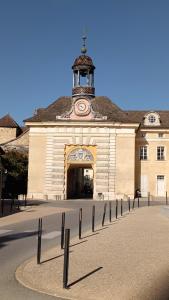 ein großes Gebäude mit einem Uhrturm darüber in der Unterkunft Le gîte de Varanges maison de ville au coeur de Givry classée 3 étoiles in Givry