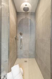 a bathroom with a shower with a glass door at The Small House at The Heaning Estate in Windermere