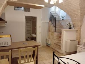 a kitchen and dining room with a table and a staircase at trullo Le murge in Alberobello