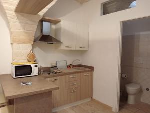 a kitchen with a sink and a microwave on a counter at trullo Le murge in Alberobello +24 photos