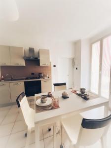una cucina bianca con tavolo da pranzo e sedie di La casa di Re Ferdinando a Napoli