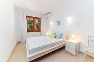 アルクーディアにあるVilla TAMARELLS Alcudiaの白いベッドルーム(ベッド1台、窓付)