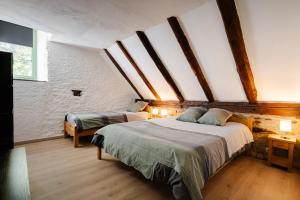 a bedroom with two beds in a attic at grange rénovée en gîte/maison/chalet in Arreau