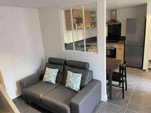 a living room with a couch and a kitchen at Maison de ville avec parking - Caen centre in Caen +11 photos