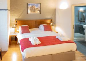 1 dormitorio con 1 cama grande y toallas. en Ghent River Hotel, en Gante