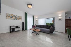 una sala de estar con un sofá y una mesa en Villa Paloma with pool, en Sukošan