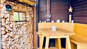 Zimmer mit einem Holztisch und einem Stapel Holz in der Unterkunft Chalet Tobeleck - CharmingStay in Flumserberg