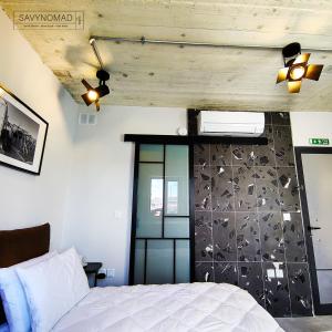 ein Schlafzimmer mit einem weißen Bett und einer Wand in der Unterkunft Cabin 4 Savynomad Harbour Residences wow Views in Cospicua