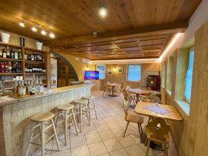 un bar con tavoli e sedie in un ristorante di Dolomites Hotel La Meridiana a Moena
