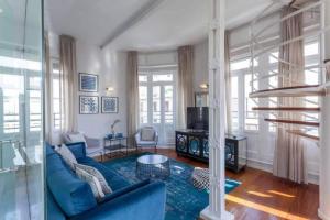 a living room with a blue couch and a television at San Vicente in Valencia