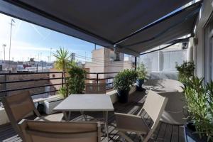 a patio with a table and chairs on a balcony at San Vicente in Valencia