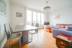 a living room with a table and a couch at Appartement spacieux 17ème arrondissement - II in Paris