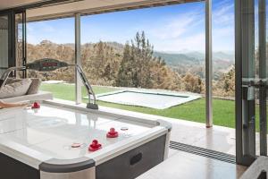 a living room with a tub and a large window at Montville Resort Style Holiday Retreat with pool in Perwillowen