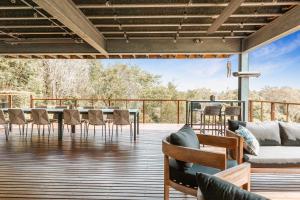 a patio with a couch and chairs on a deck at Montville Resort Style Holiday Retreat with pool in Perwillowen