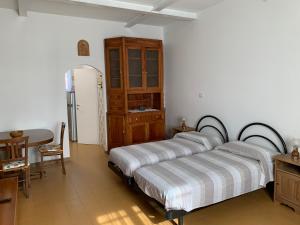 a bedroom with two beds and a table and a refrigerator at Al sit ed Marino in Castel Maggiore