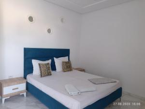 a bedroom with a large bed with a blue headboard at LEO Haute standing appartment S1 center Monastir in Monastir