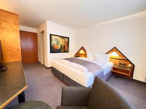 Habitación de hotel con cama y silla en Hotel Residenz en Bad Neustadt an der Saale