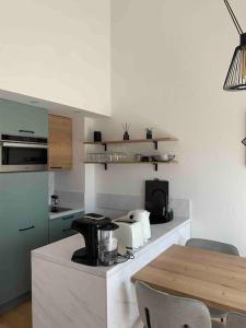 eine Küche mit einem Tisch und einer Arbeitsplatte in der Unterkunft Appartement duplex Porticcio avec parking in Porticcio