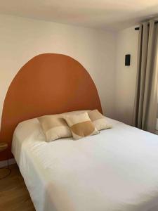Schlafzimmer mit einem großen weißen Bett mit einem Kopfteil aus Holz in der Unterkunft Appartement duplex Porticcio avec parking in Porticcio