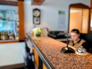 un hombre sentado en un bar con una encimera en Hotel Residenz en Bad Neustadt an der Saale