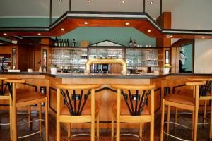 a bar in a restaurant with wooden stools at Hotel Residenz in Bad Neustadt an der Saale