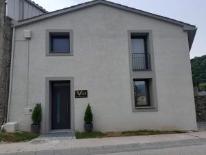 a white house with a sign that says vaan at Apartaments Vall del Corb 1 Garrotxa in San Miguel del Corp