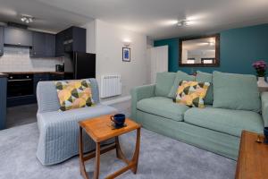 南安普敦的住宿－2 Bedroom City Centre Apartment, Sleeps up to 6 Guests, Free Parking，客厅配有两张绿色沙发和一张桌子