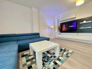 een woonkamer met een blauwe bank en een tafel bij Central cozy Apartment in Cluj-Napoca