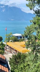 a row of yellow umbrellas in front of the ocean at Appartement vue lac Montreux in Montreux
