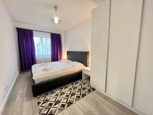 een slaapkamer met een bed en een raam met paarse gordijnen bij Central cozy Apartment in Cluj-Napoca