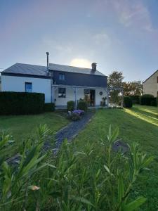 a white house with a grassy yard at Les marmottes - Maison de vacances La Roche-en-Ardenne in La Roche-en-Ardenne