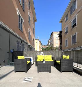 een patio met 2 stoelen en een tafel met gele kussens bij Green House Varazze in Varazze